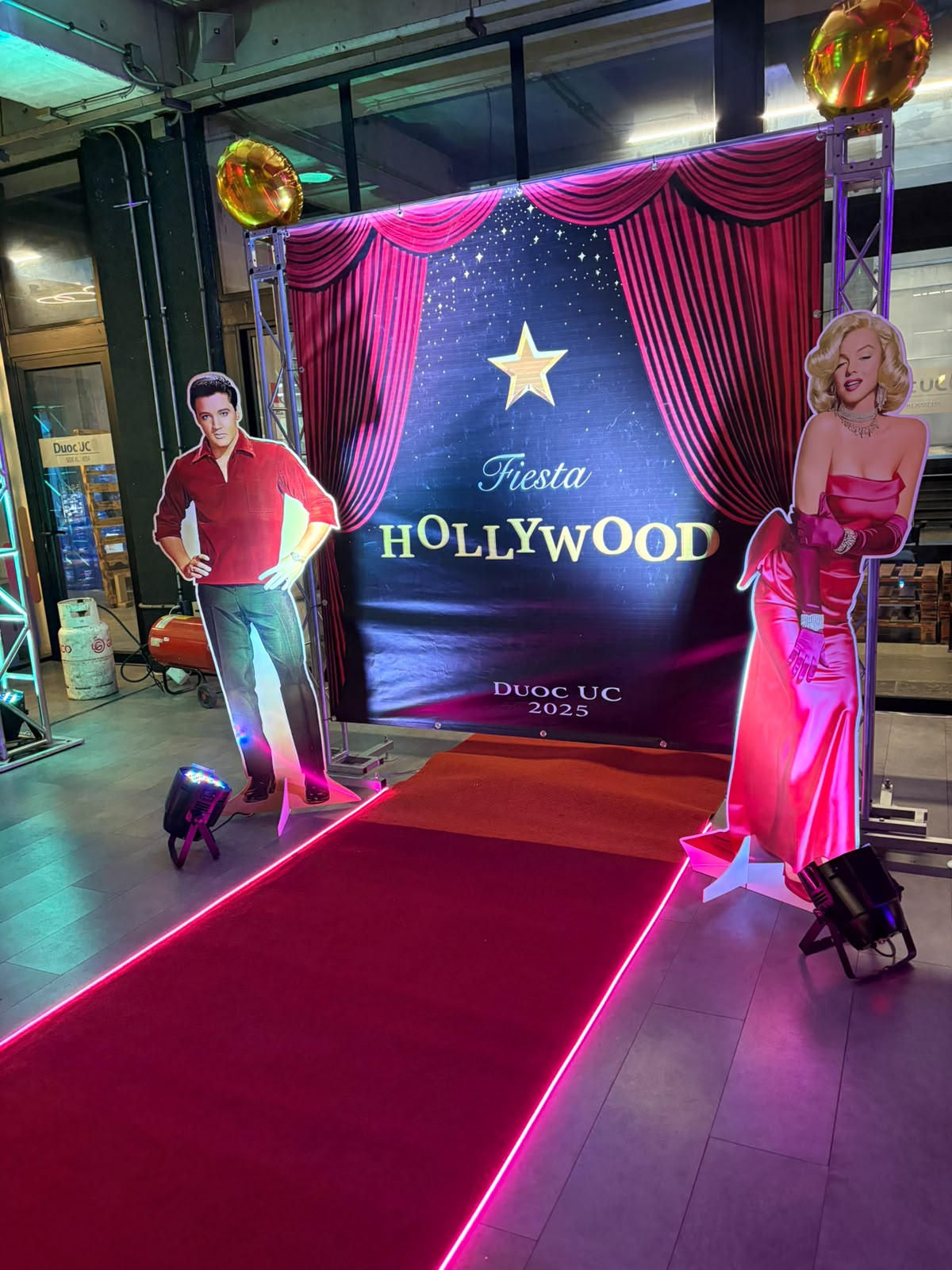 Ambientación temática Fiesta Hollywood con alfombra roja y luces de escenario